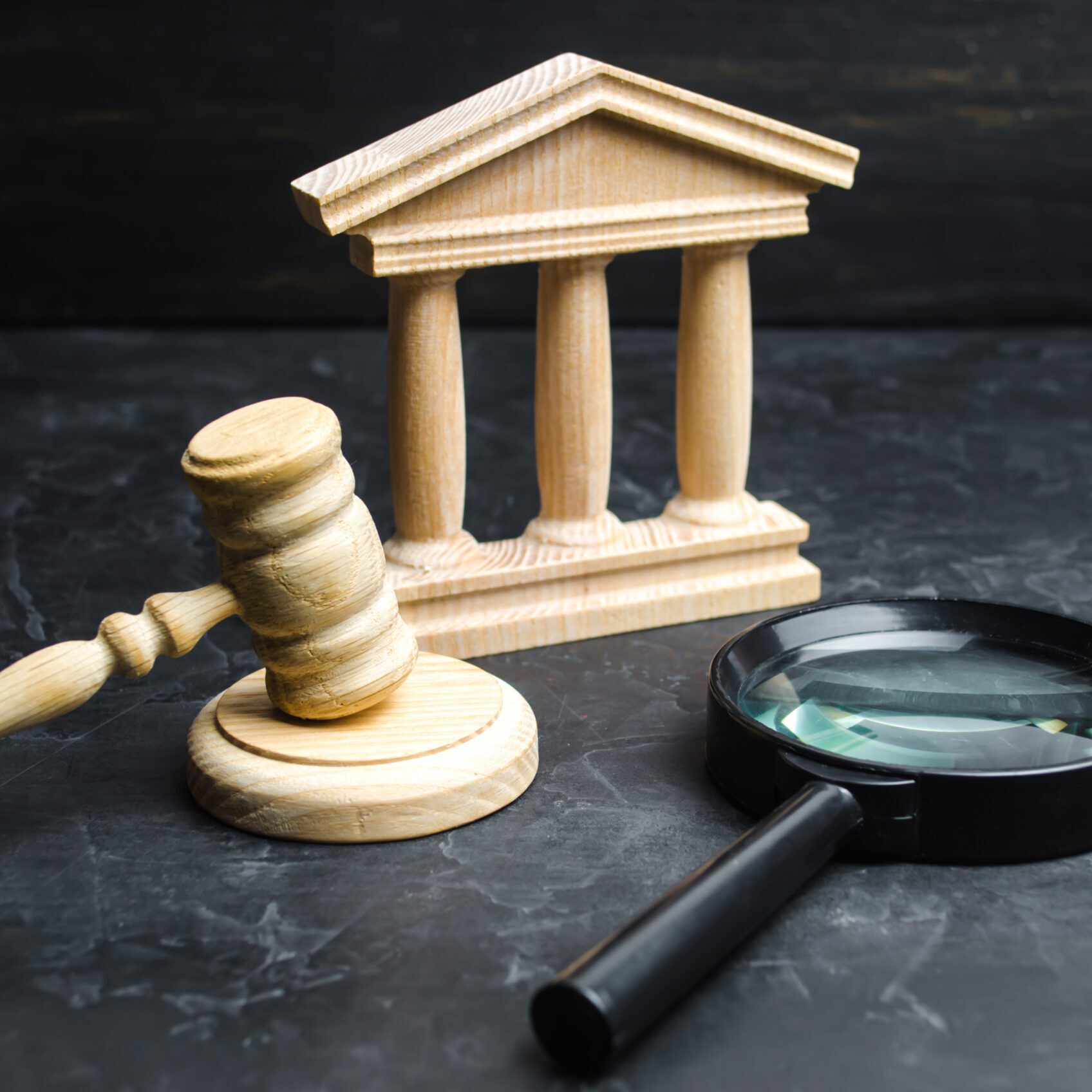 Magnifying glass lies near the courthouse. Lawsuits, verdict and bills. Constitutional Court. Human rights obstruction, power control and transparency, anti-corruption. Selective focus